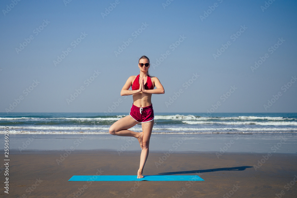 Caucasian woman practicing yoga at seashore Caucasian woman practicing yoga at seashore