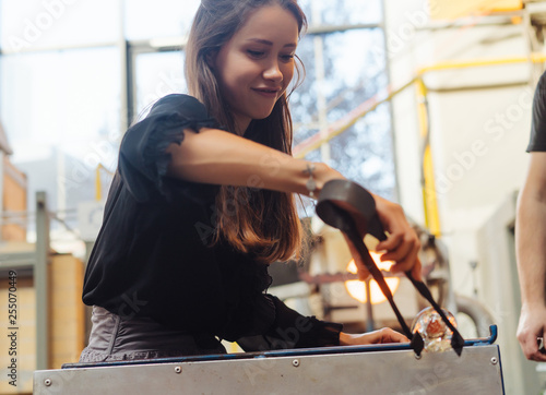 A glassblower student tries to make a flower out of glass