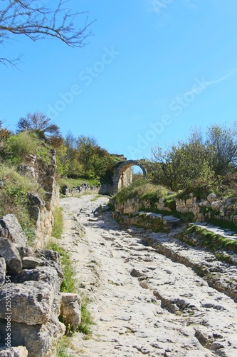 The central street of the cavecity Chufut-Kale. Above the road is visible arch, left from the gate in the fortified wall. It's a medieval city-fortress in the Crimean Mountains that now lies in ruins.