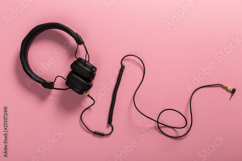 black headphones on pastel background.