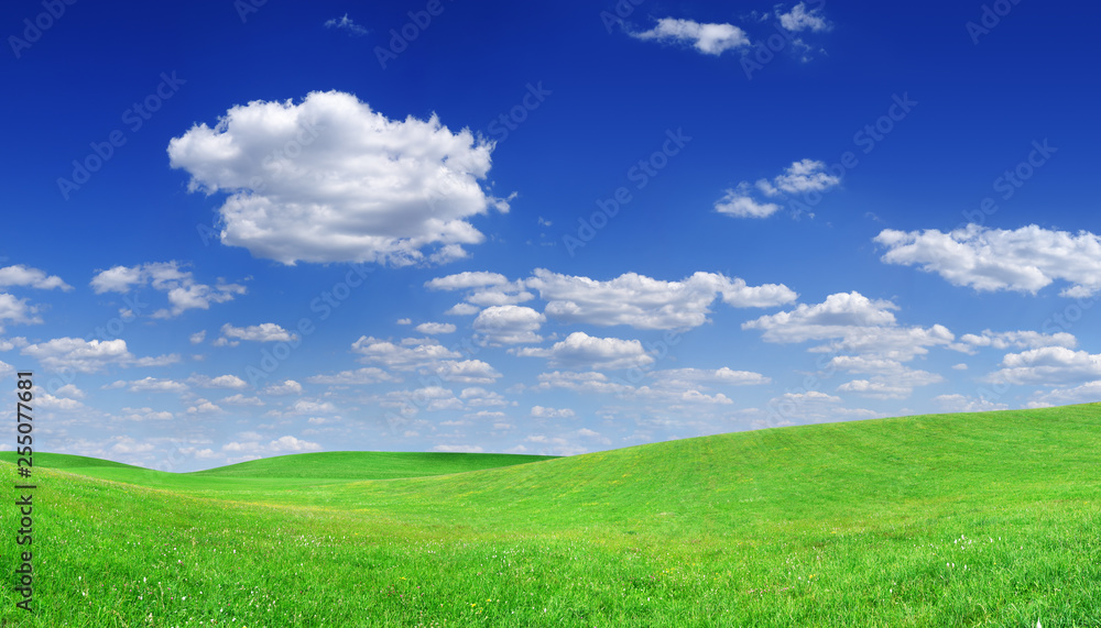 Idyllic view, green hills and blue sky with white clouds