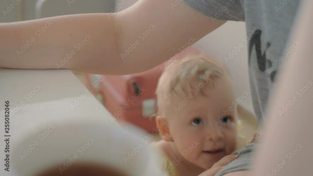 One year old baby girl coming to mum and trying to attract her attention when she working on laptop. Home video imitation One year old baby girl coming to mum and trying to attract her attention when she working on laptop. Home video imitation