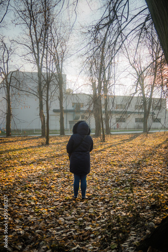 Girl at autumn in blue clothes exploring in the park