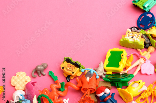 Top view on colorful toy bricks on a pink background. Colorful kids toys frame with copy space for text. Flat lay.