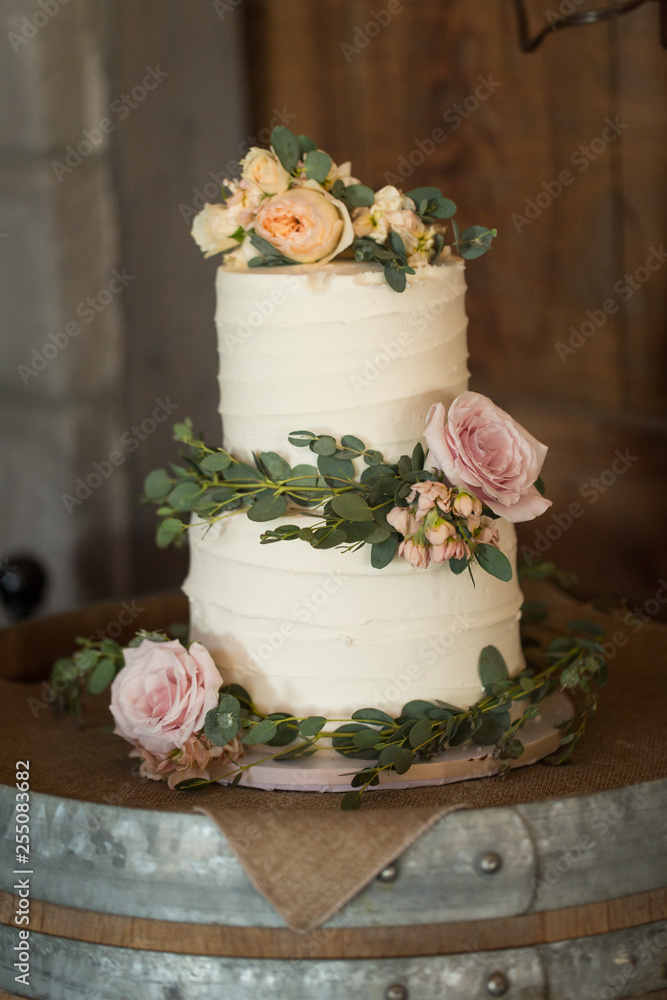 wedding cake with real roses and greenery on a wine barrel Stock Photo