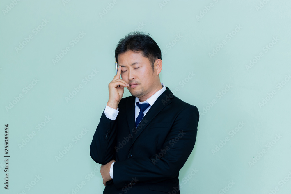 A studio image of an Asian businessman with a handsome beard and holding pen a mint green background A studio image of an Asian businessman with a handsome beard and holding pen a mint green background