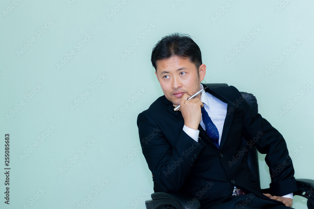 A studio image of an Asian businessman with a handsome beard and holding pen a mint green background A studio image of an Asian businessman with a handsome beard and holding pen a mint green background