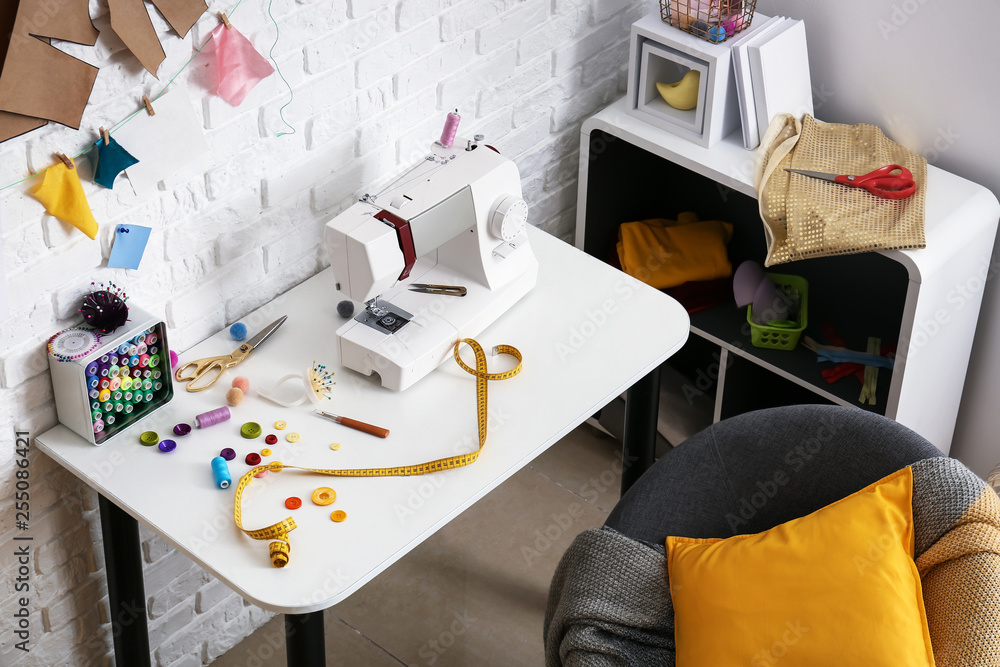 Stylish workplace of tailor with sewing machine in workshop
