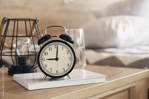 Alarm clock on table in bedroom photo