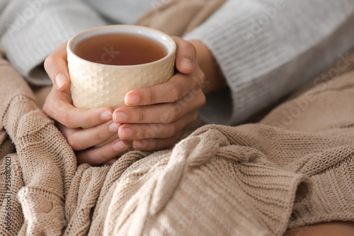 Fotografia Young woman drinking hot tea at home, closeup