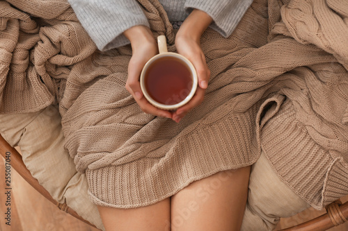 Fotografia Young woman drinking hot tea at home