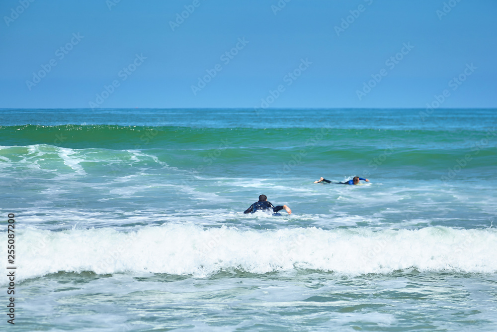 Surfing. A surfer catches a wave. Men on surfboards. Sunny summer day Surfing. A surfer catches a wave. Men on surfboards. Sunny summer day