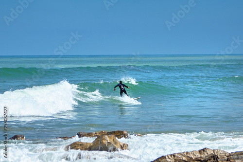 Surfing. A surfer catches a ocean wave. Man on surfboard