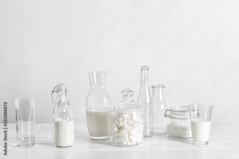 Glassware with milk and sugar on white table Glassware with milk and sugar on white table