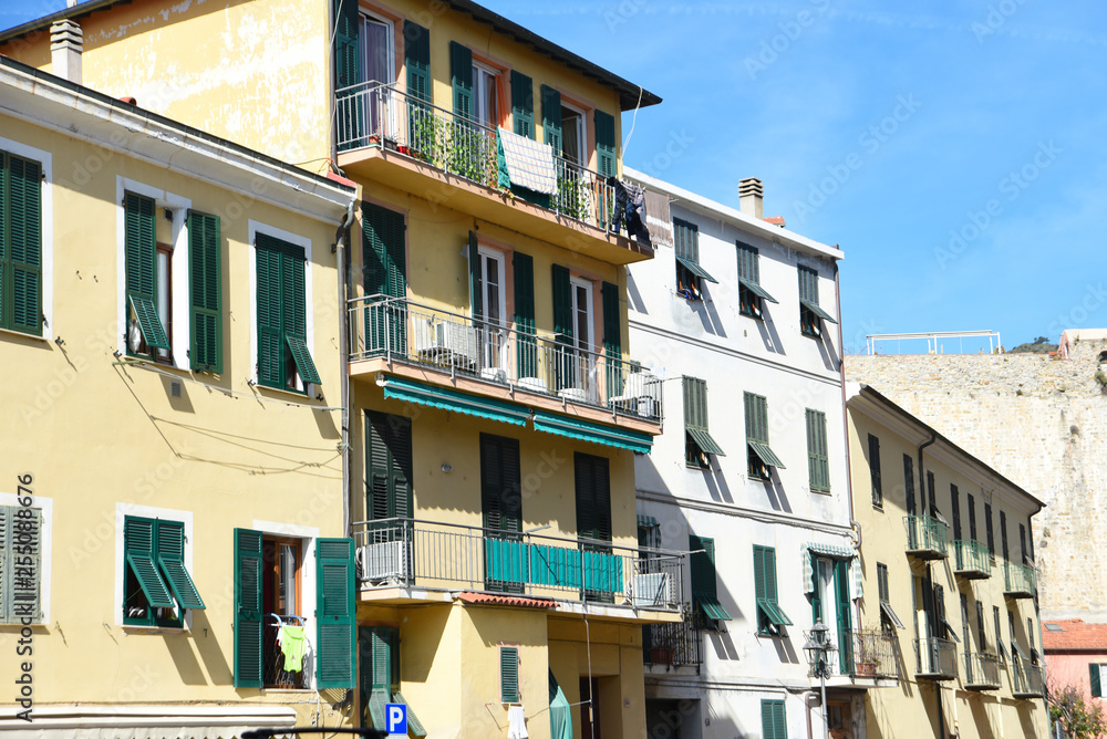 Southern italian street. Sunny houses with window shutters Southern italian street. Sunny houses with window shutters