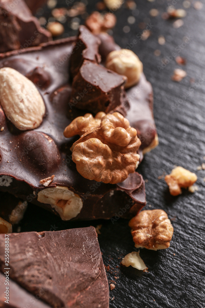 Sweet tasty chocolate with nuts on dark background