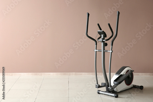 Modern exercise machine near color wall