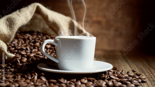 Czarna kawa na starych deskach i rozsypane ziarna