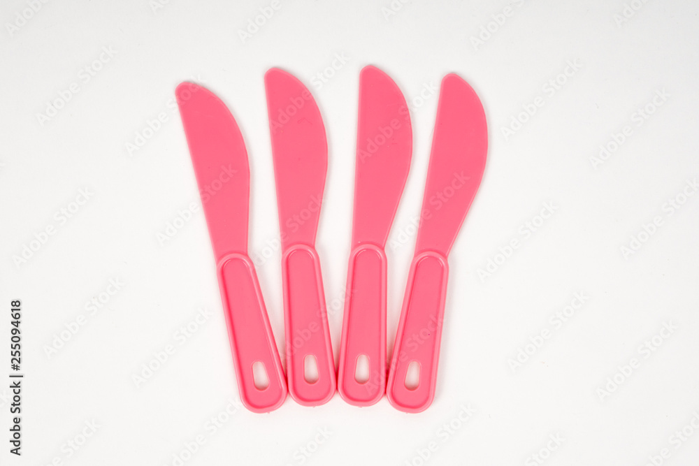 Pink plastic children knives on a white background Pink plastic children knives on a white background