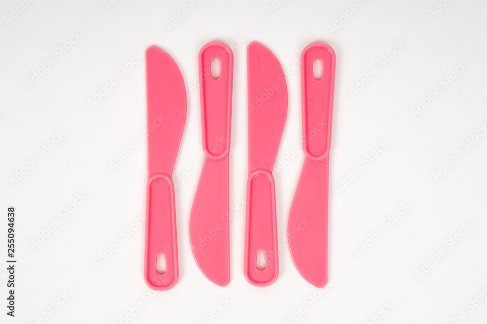 Pink plastic children knives on a white background Pink plastic children knives on a white background