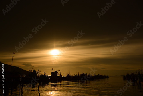 Fishing port view before sunset With beautiful golden yellow sky © tharathip