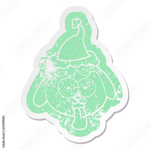 cartoon distressed sticker of a dog face panting wearing santa hat