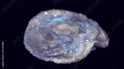 Seamlessly rotating a blue mineral (Chalcedone Rose) in front of black background photo