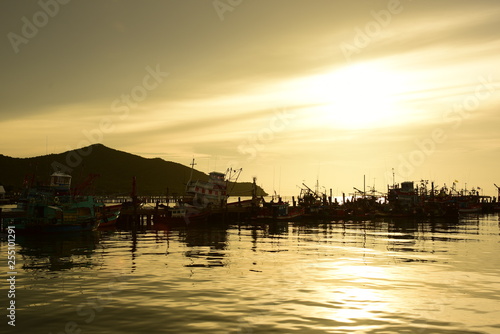 Fishing port view before sunset With beautiful golden yellow sky © tharathip
