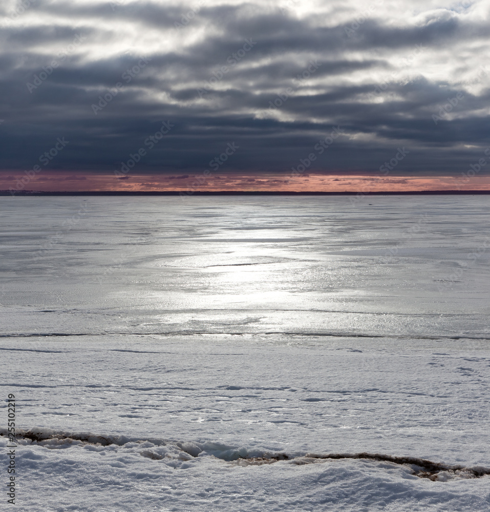 Sunset in winter on the shore of the frozen Baltic Sea