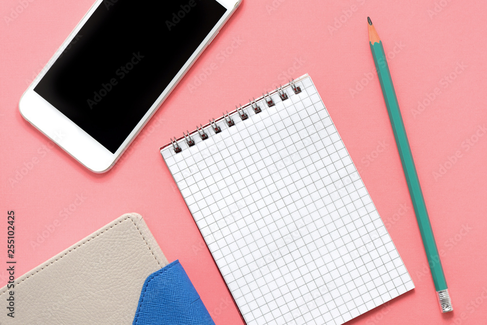 Blank notepad, organizer, phone and pencil on pink background close up Blank notepad, organizer, phone and pencil on pink background close up