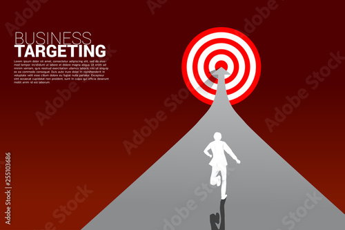 silhouette of businessman running on arrow to center of dartboard. Business Concept of targeting and customer.Company vision mission.