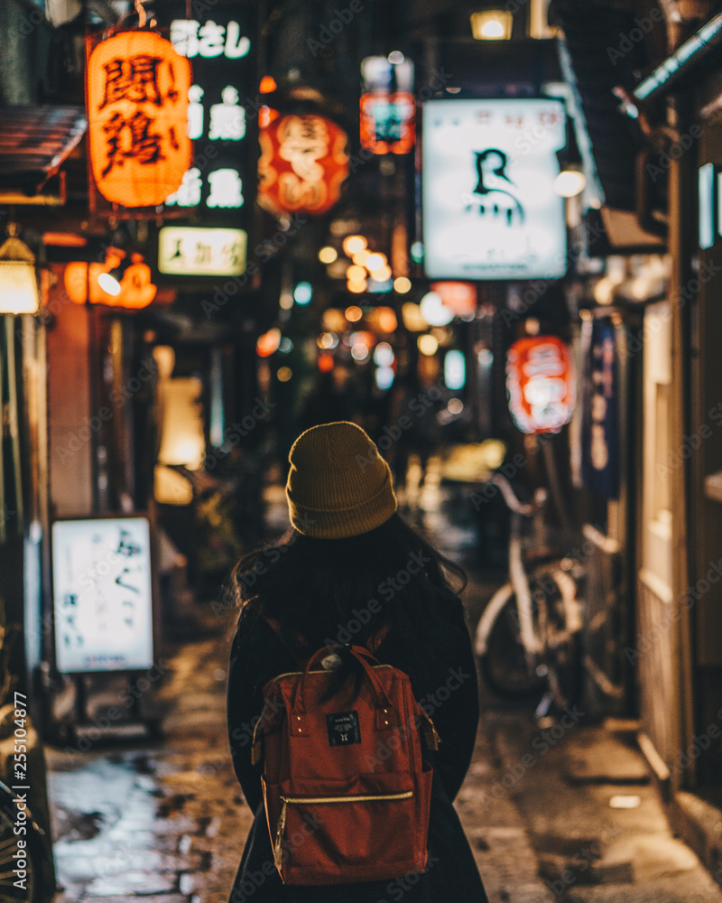 Obraz premium Woman tourist wearing beanie walking the colourful streets of Osaka, Japan.