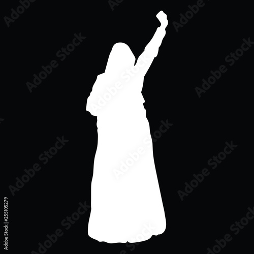 A woman in long dress, with a hood on her head, is raising her hand in protest