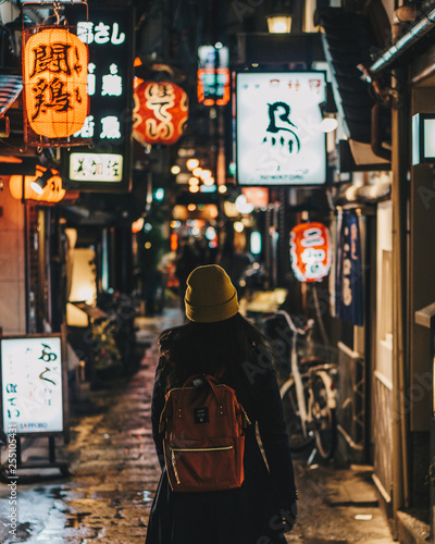 Photography Woman tourist wearing beanie walking the colourful streets of Osaka, Japan
