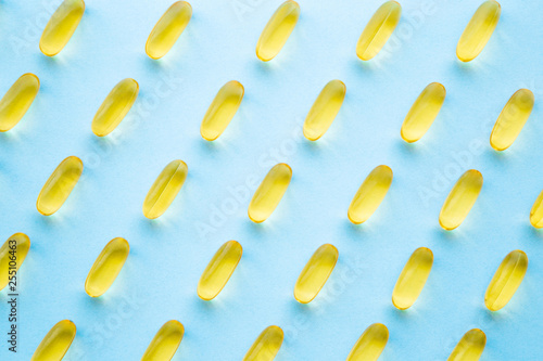 Billede på lærred Fish oil capsules on light pastel blue table