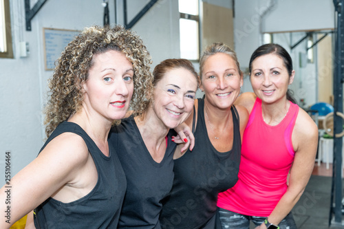 Happy four women at the gym, relaxing after workouts. Happiness and business concept