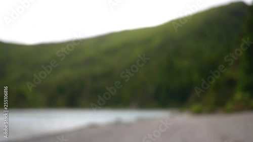 young girl smoking vape in nature and blowing smoke into the camera