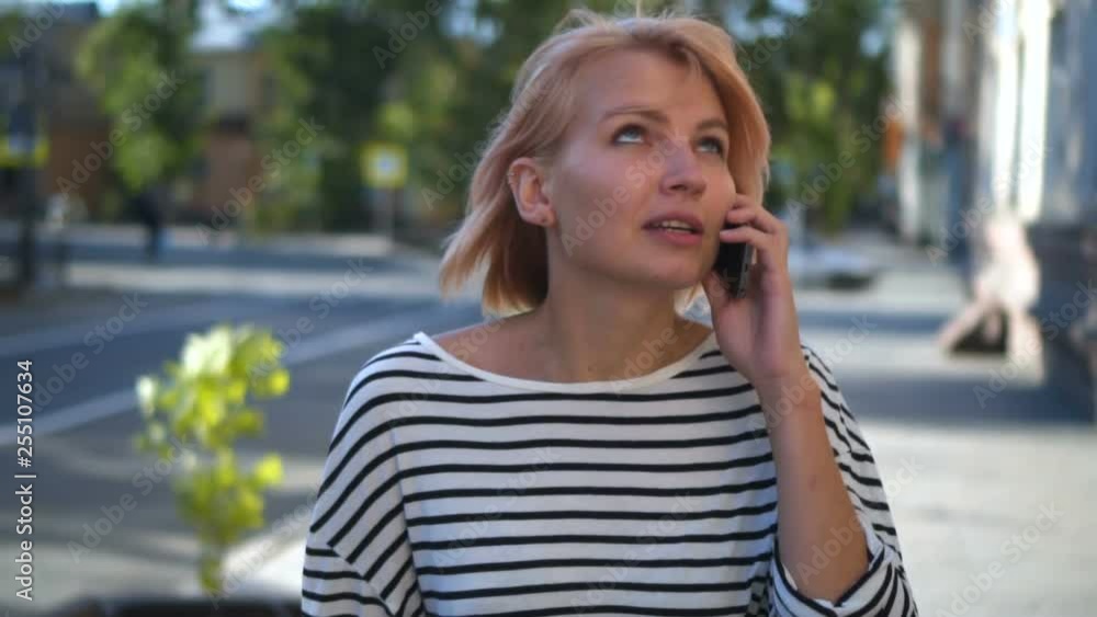 Woman walking In the city talking to cellphone Woman walking In the city talking to cellphone
