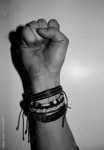 Hand gesture - Hippie hand with multiple bracelets clenced in a fist - Black and white photo