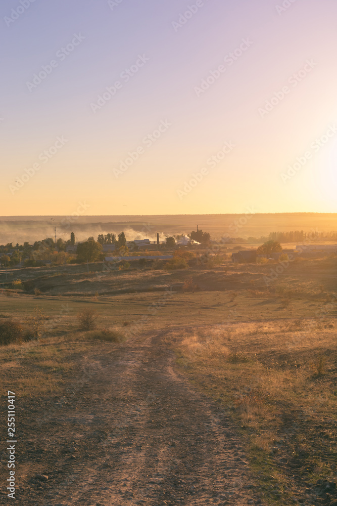 Fototapeta premium Smoke over the village in the autumn. Burning foliage in Ukraine.