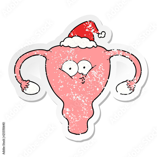 distressed sticker cartoon of a uterus wearing santa hat