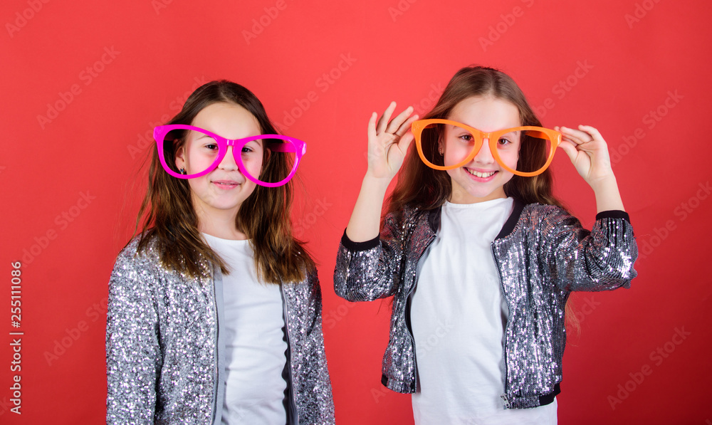 Obraz premium Sisterhood concept. Friendly relations siblings. Sincere cheerful kids share happiness and love. Girls funny big eyeglasses cheerful smile. Birthday party. Happy childhood. Joyful and cheerful