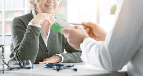 Professional doctor giving a prescription medicine to a senior patient