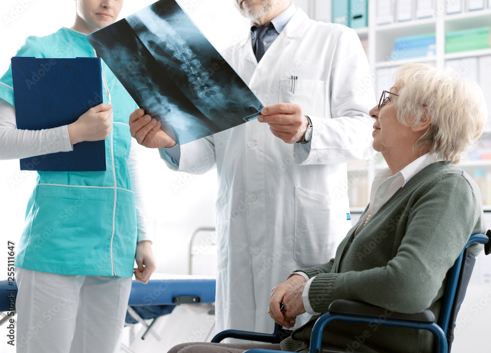 Fototapeta premium Doctor checking a senior patient's x-ray image