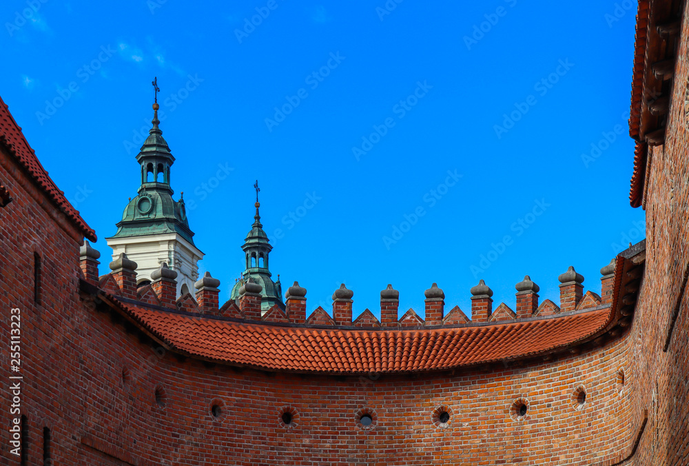 Two towers with spiers and red brick walls of Warsaw Barbican, Poland