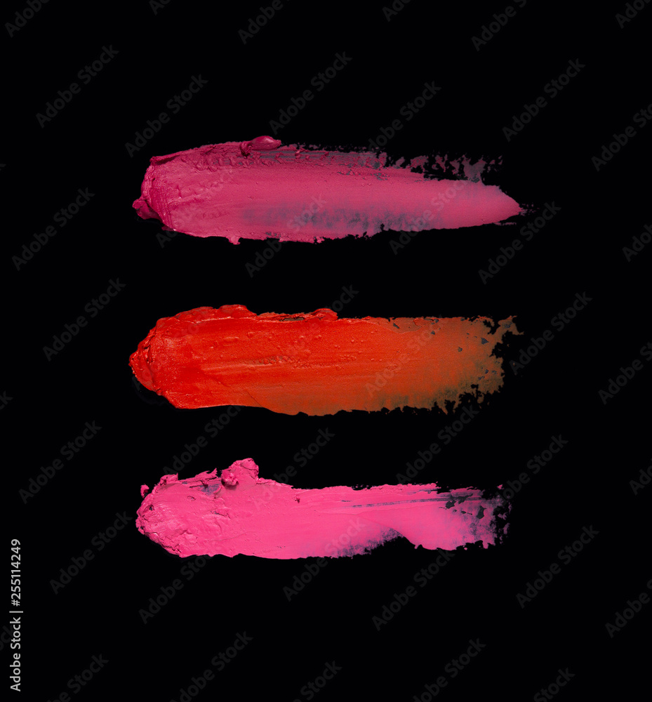 Creative concept photo of cosmetics swatches beauty products lipstick on black background.