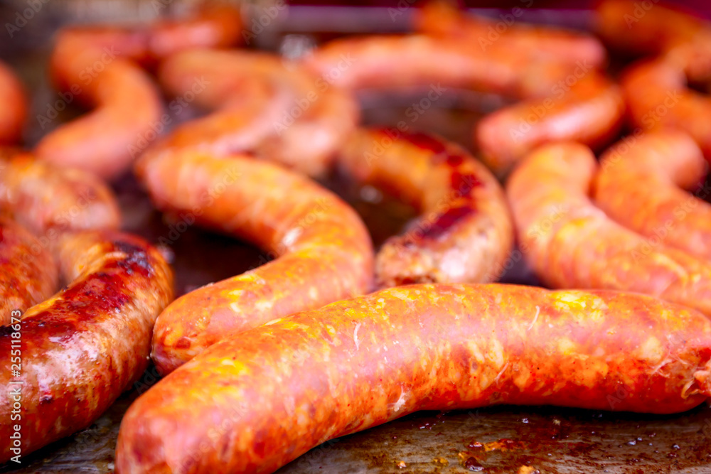 Fototapeta premium Baking delicious juicy sausages on barbecue plate