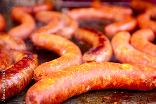 Baking delicious juicy sausages on barbecue plate