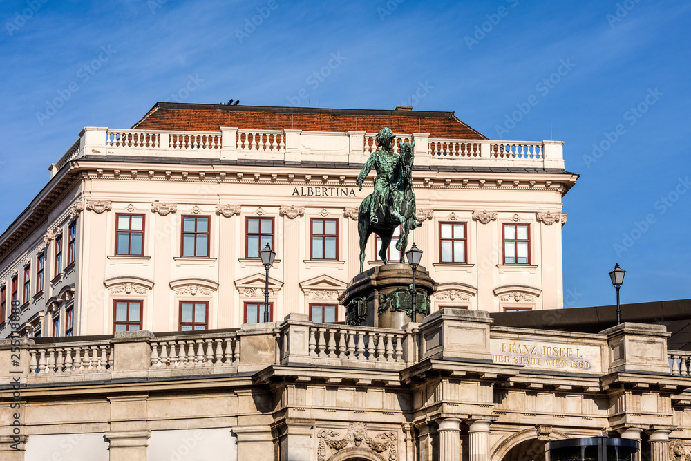 Austria, Vienna, Albrechtsplatz: Front view of world famous Albertina museum palais palace with Albrecht statue in the city center of the Austrian capital with blue sky - concept travel history art