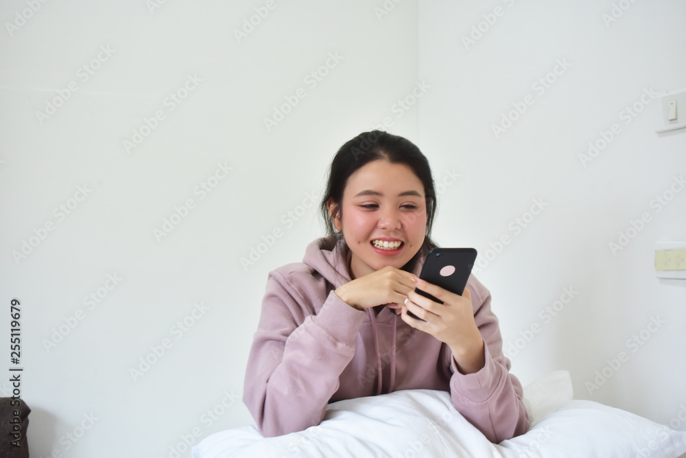 Women using mobile smartphone is ion bedroom Women using mobile smartphone is ion bedroom